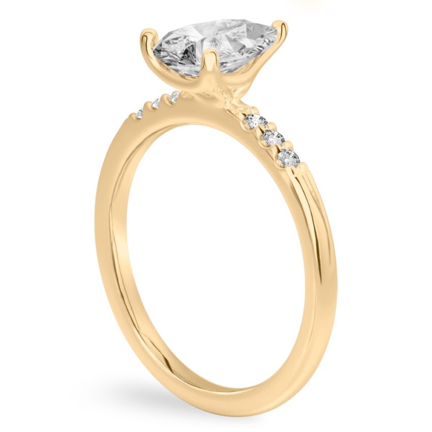 Angle view of pear shape diamond minimalist pave engagement ring in yellow gold