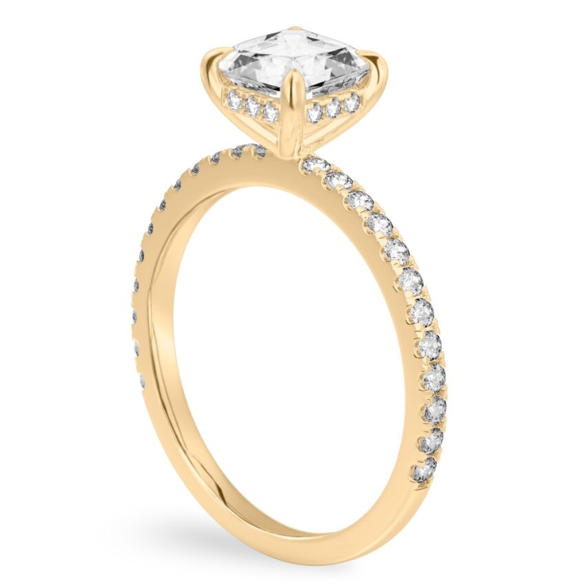 Angle view of asscher cut diamond delicate pave hidden halo engagement ring in yellow gold