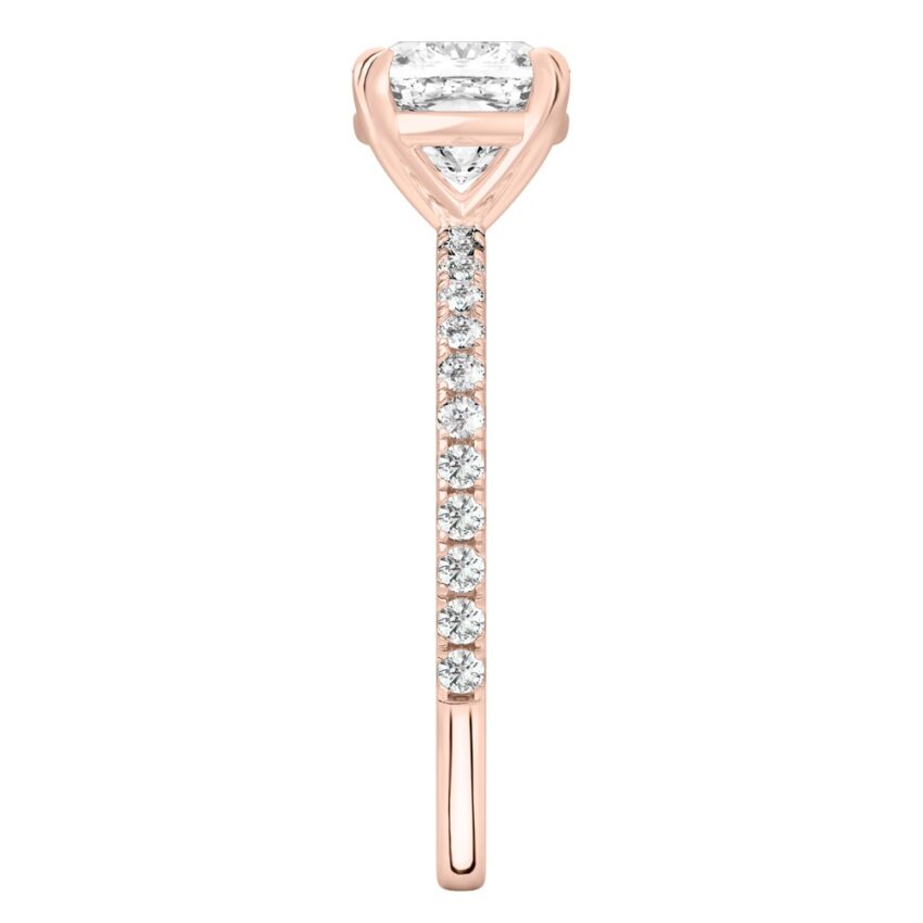 Side view of cushion cut diamond delicate pave engagement ring in rose gold