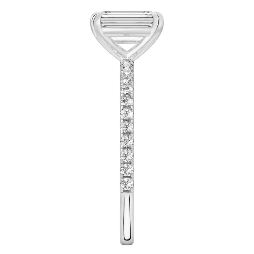 Side view of emerald cut diamond delicate pave engagement ring in palladium