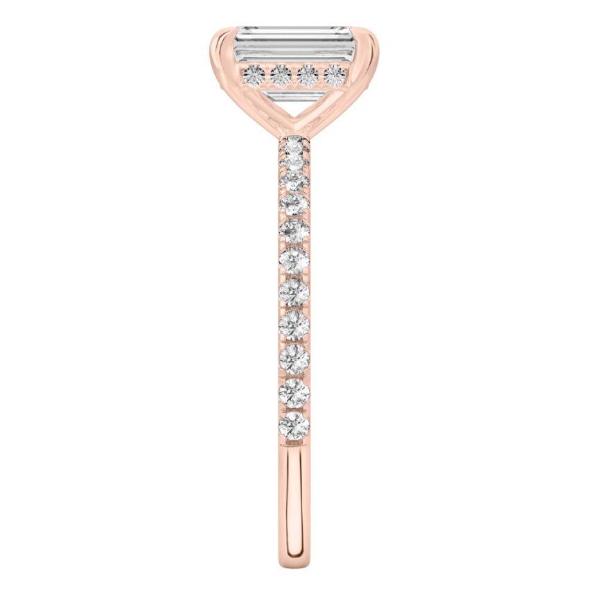 Side view of emerald cut diamond delicate pave hidden halo engagement ring in rose gold