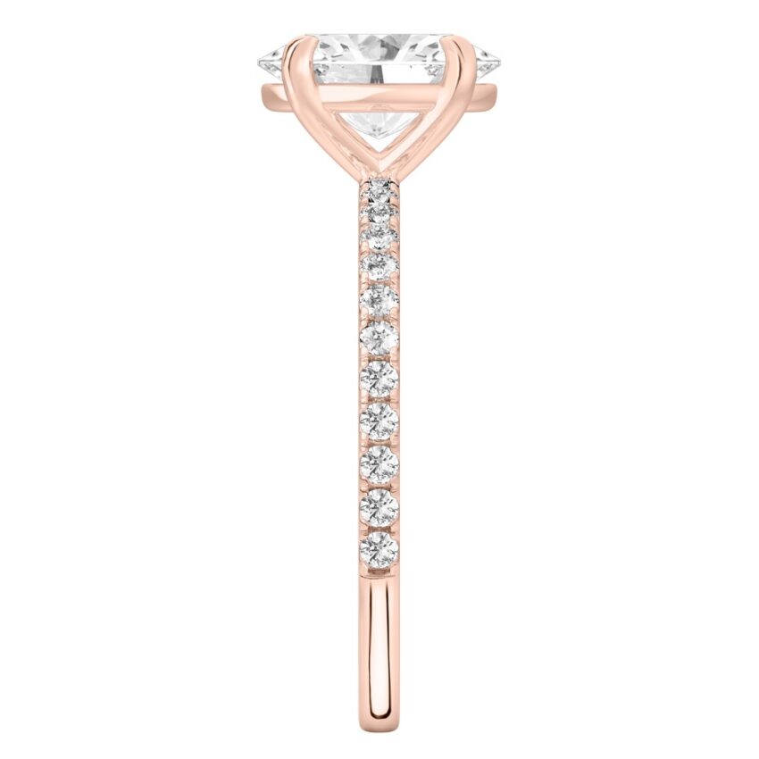 Side view of oval cut diamond delicate pave engagement ring in rose gold