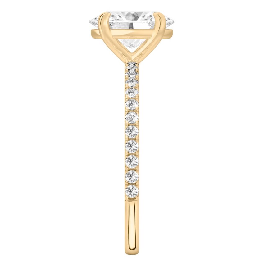 Side view of oval cut diamond delicate pave engagement ring in yellow gold