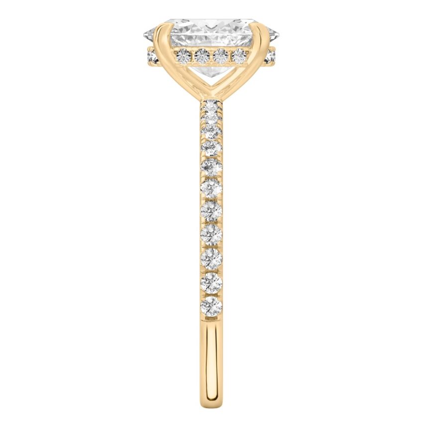 Side view of oval cut diamond delicate pave hidden halo engagement ring in yellow gold