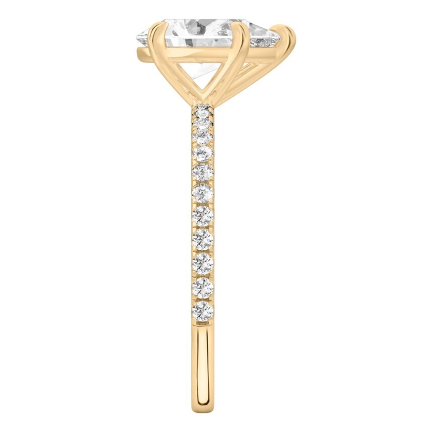 Side view of pear shape diamond delicate pave engagement ring in yellow gold
