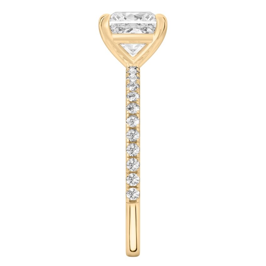 Side view of princess cut diamond delicate pave engagement ring in yellow gold
