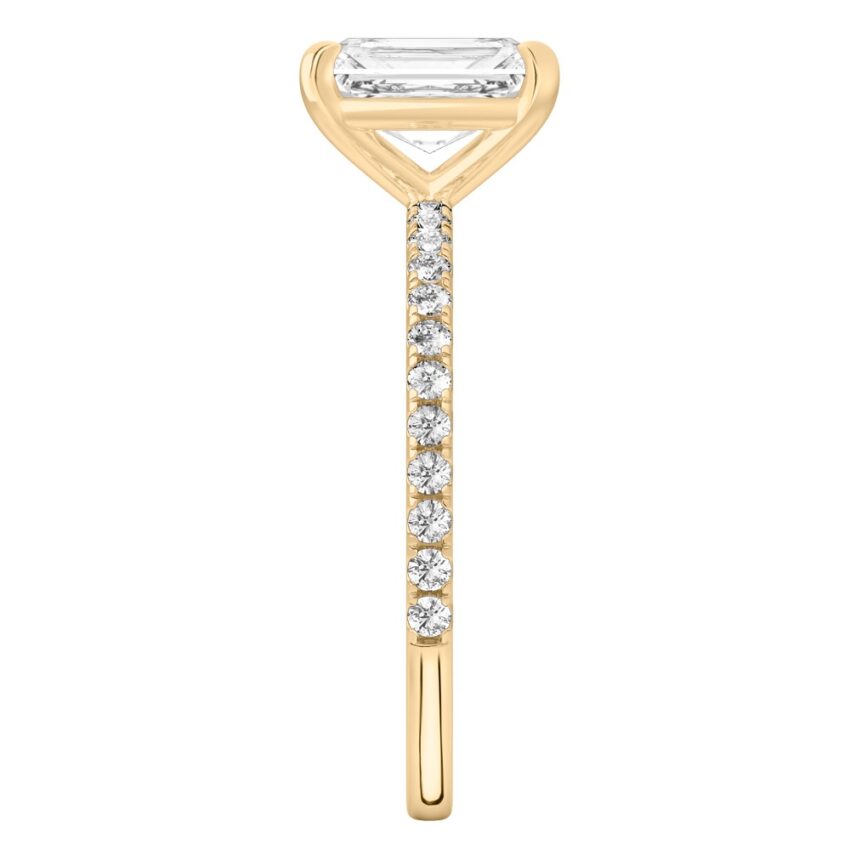 Side view of radiant cut diamond delicate pave engagement ring in yellow gold