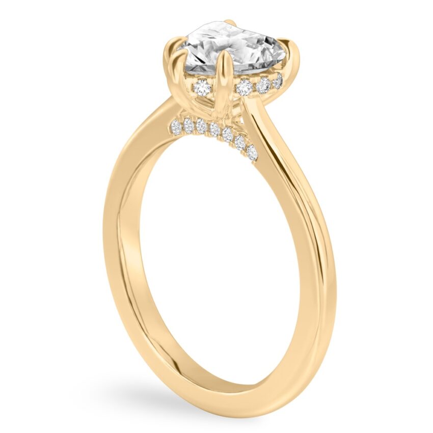 Angle view of heart shape diamond pave bridge engagement ring in yellow gold