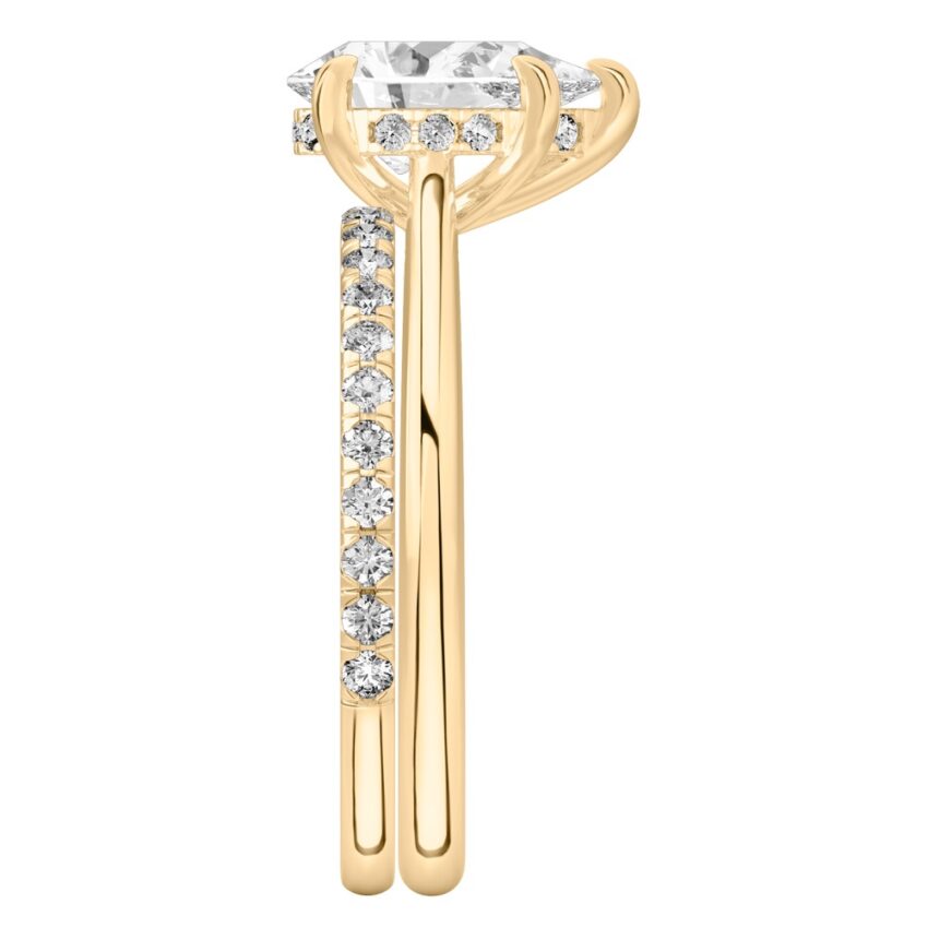 Side view of pear shape diamond pave bridge engagement ring set yellow gold