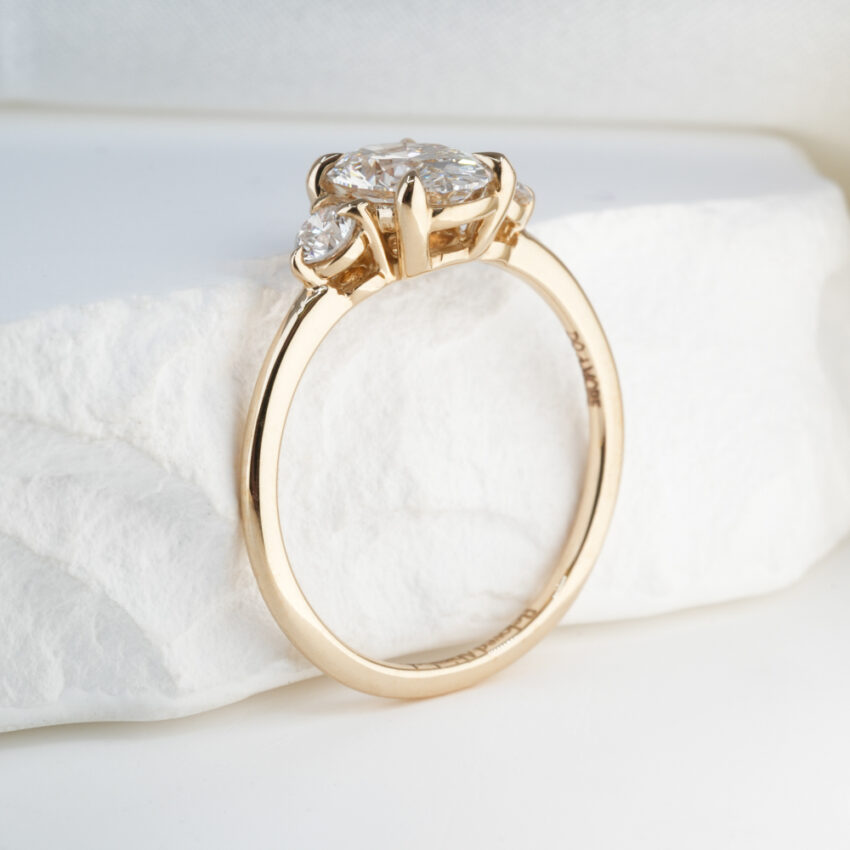 1.19 Carat Oval Cut Diamond Three Stone Engagement Ring Yellow Gold Lifestyle Angle