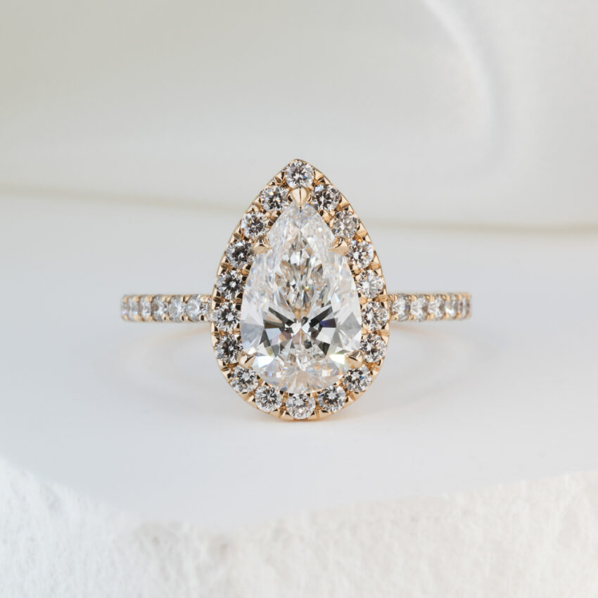 1.50 carat pear cut diamond cushion halo engagement ring in yellow gold lifestyle