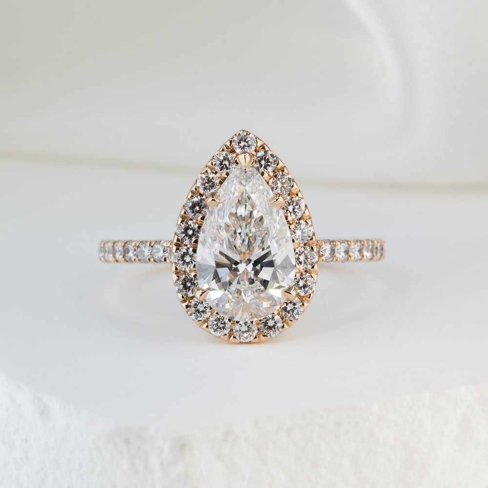 1.50 carat pear cut diamond cushion halo engagement ring in yellow gold lifestyle