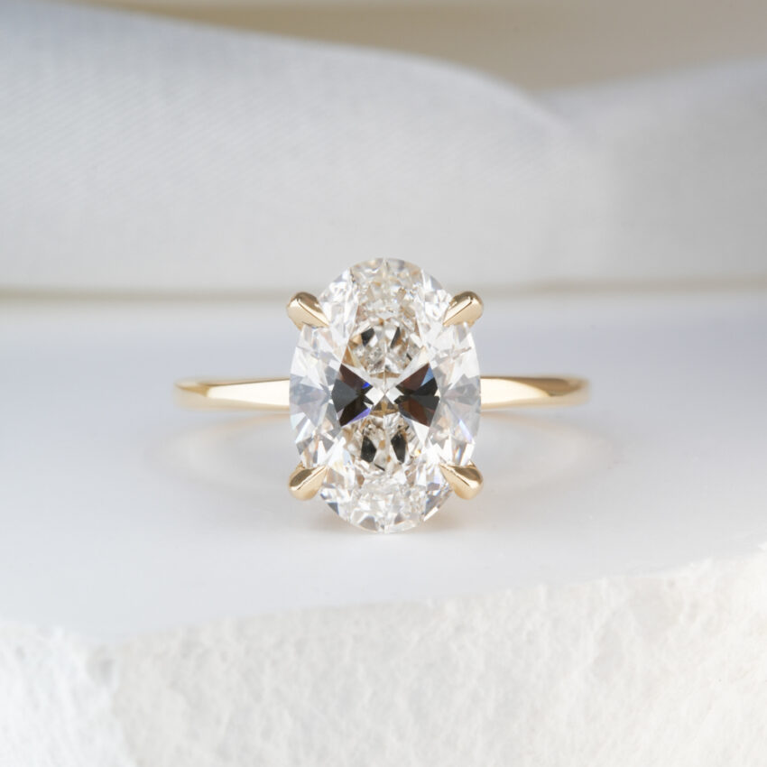 2.0 Carat Oval Cut Diamond Ultra Low Hidden Halo Engagement Ring Yellow Gold Lifestyle