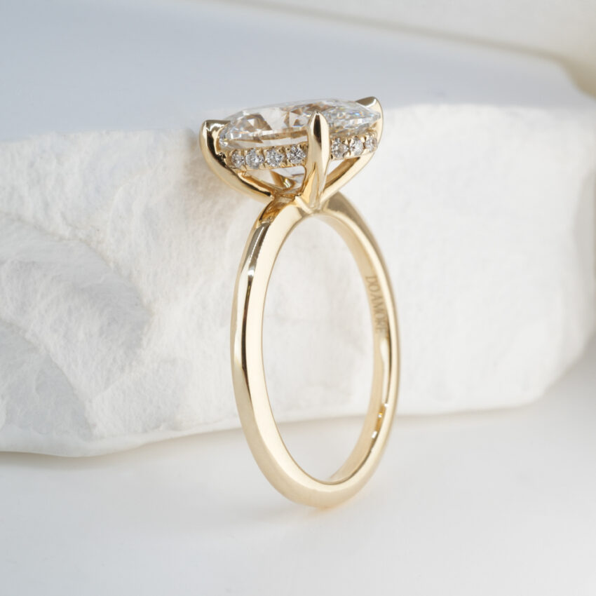 2.0 Carat Oval Cut Diamond Ultra Low Hidden Halo Engagement Ring Yellow Gold Lifestyle Angle