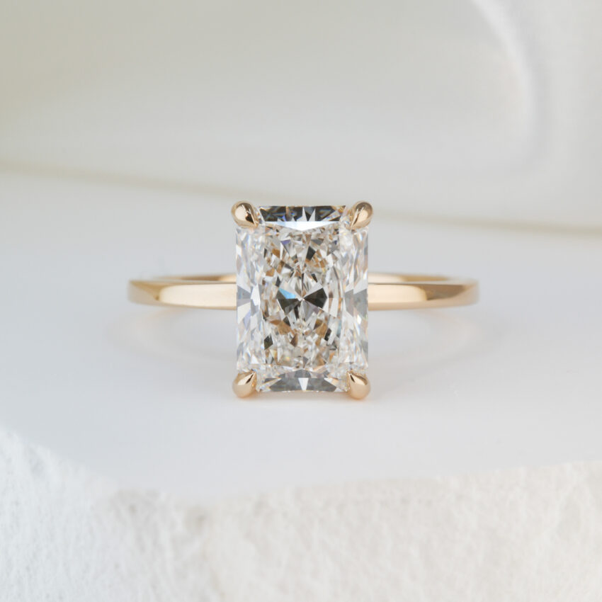 2.43 carat radiant cut diamond ultra low hidden halo engagement ring in yellow gold lifestyle