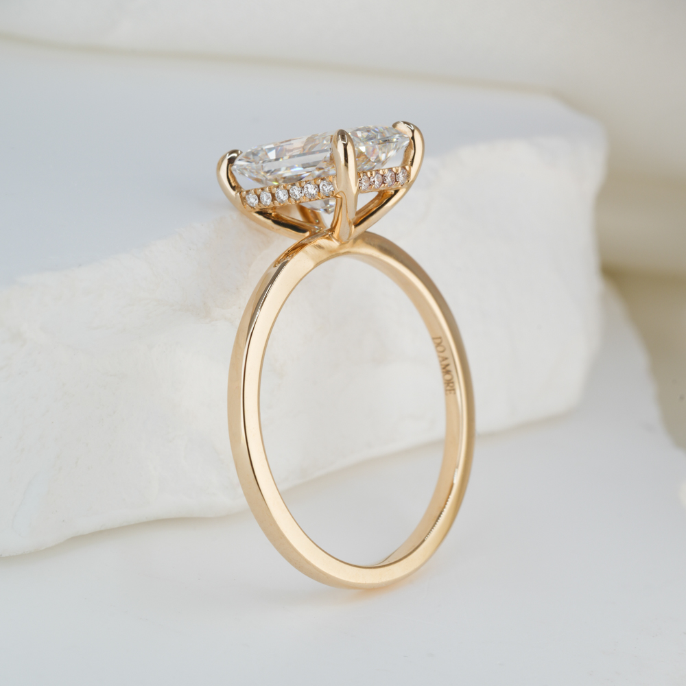 Angle view of 2.43 carat radiant cut diamond ultra low hidden halo engagement ring in yellow gold lifestyle