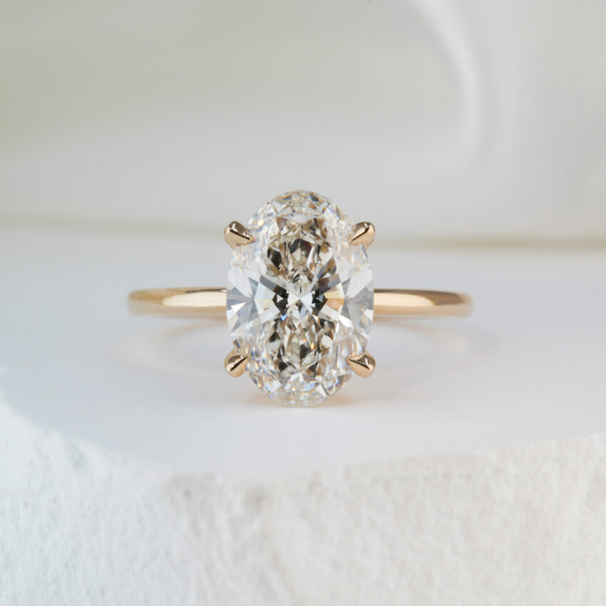 2.51 carat oval cut diamond delicate solitaire engagement ring in yellow gold lifestyle
