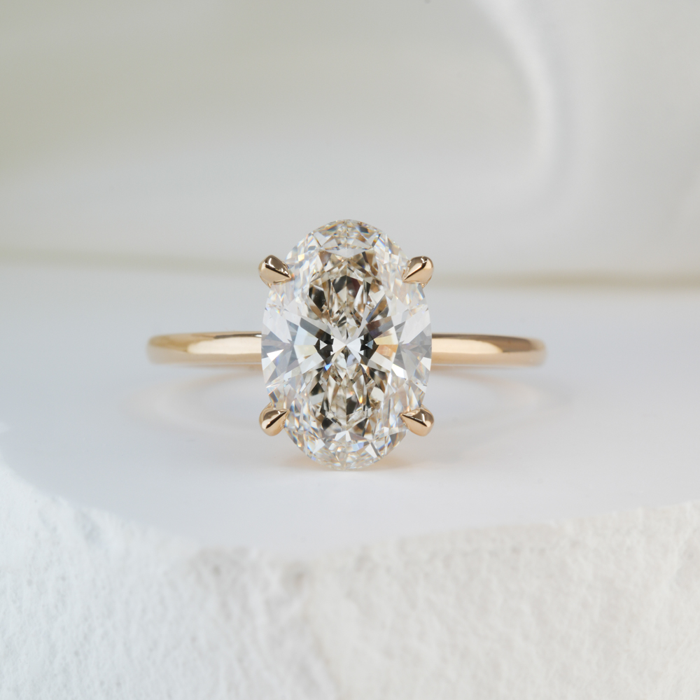 2.51 carat oval cut diamond delicate solitaire engagement ring in yellow gold lifestyle