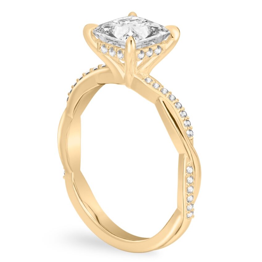 Angle view of princess cut diamond twist hidden halo engagement ring in yellow gold