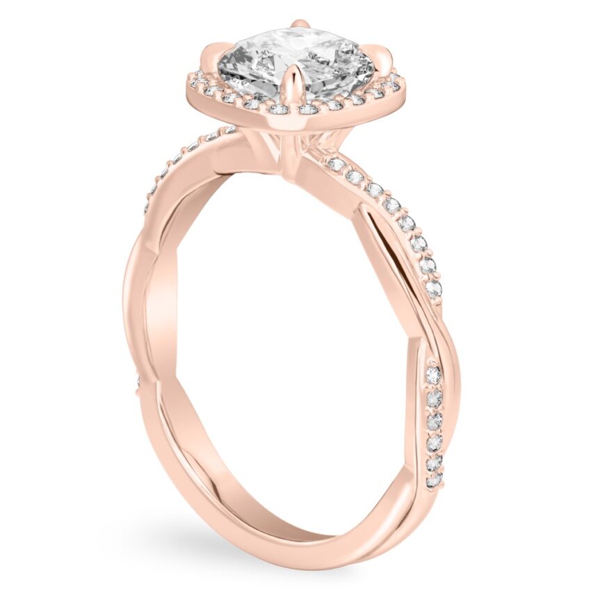 Angle view of cushion cut diamond twist halo engagement ring in rose gold