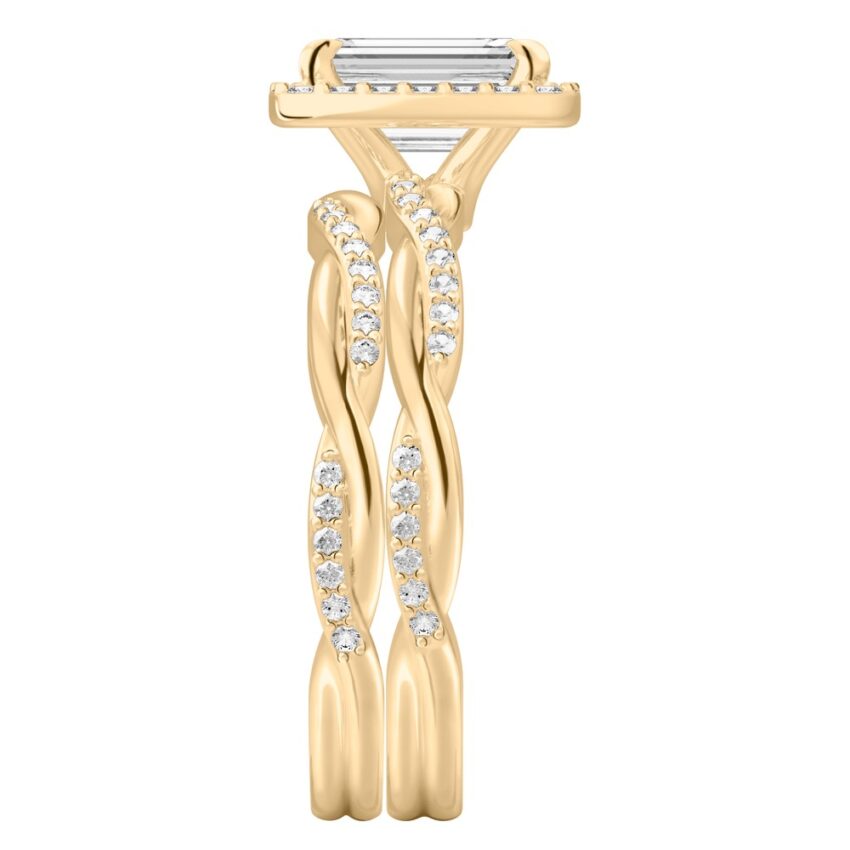 Side view of emerald cut diamond twist halo engagement ring set yellow gold