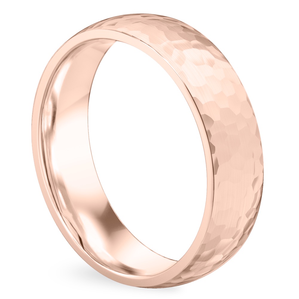 Angle view of domed hammered wedding band in rose gold