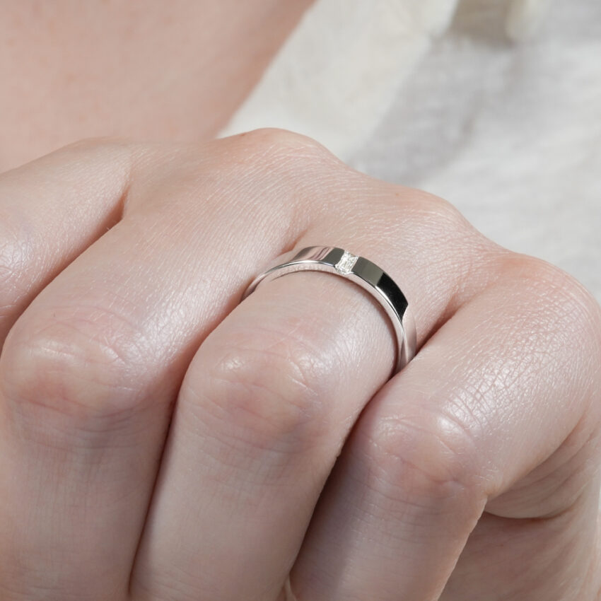 Angle view of flush baguette wedding band in lifestyle