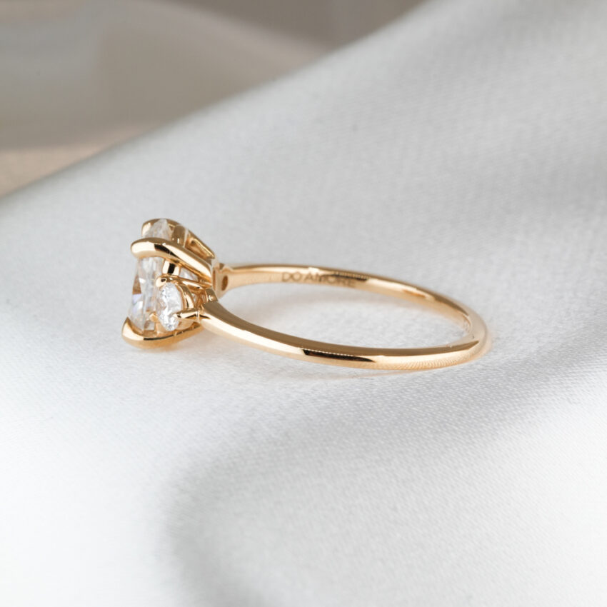 1.80 carat three stone engagement ring_yellow gold_lifestyle_side Side view of 1.80 carat three stone engagement ring in_yellow gold_lifestyle_side