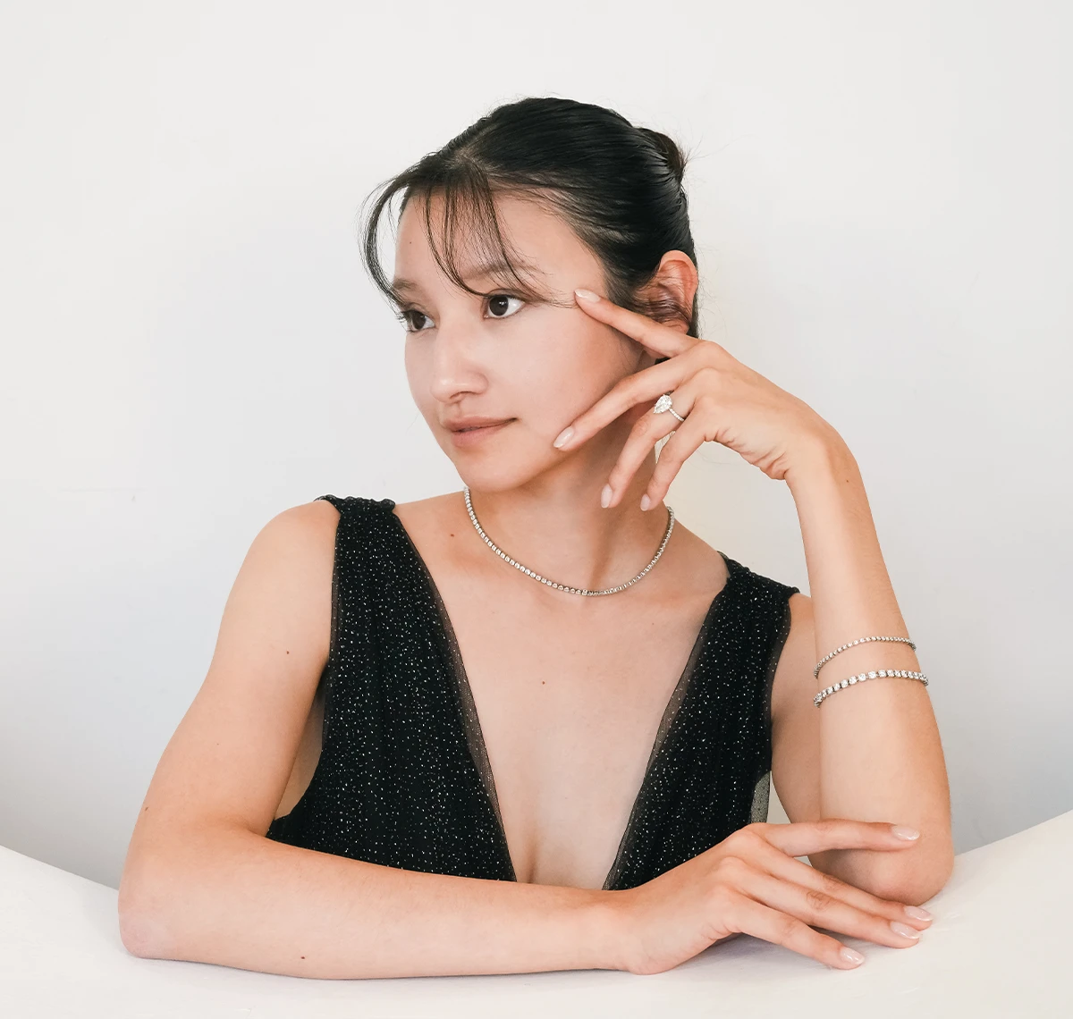 Woman wearing a diamond engagement ring, everyday tennis bracelet and fine jewelry by Do Amore