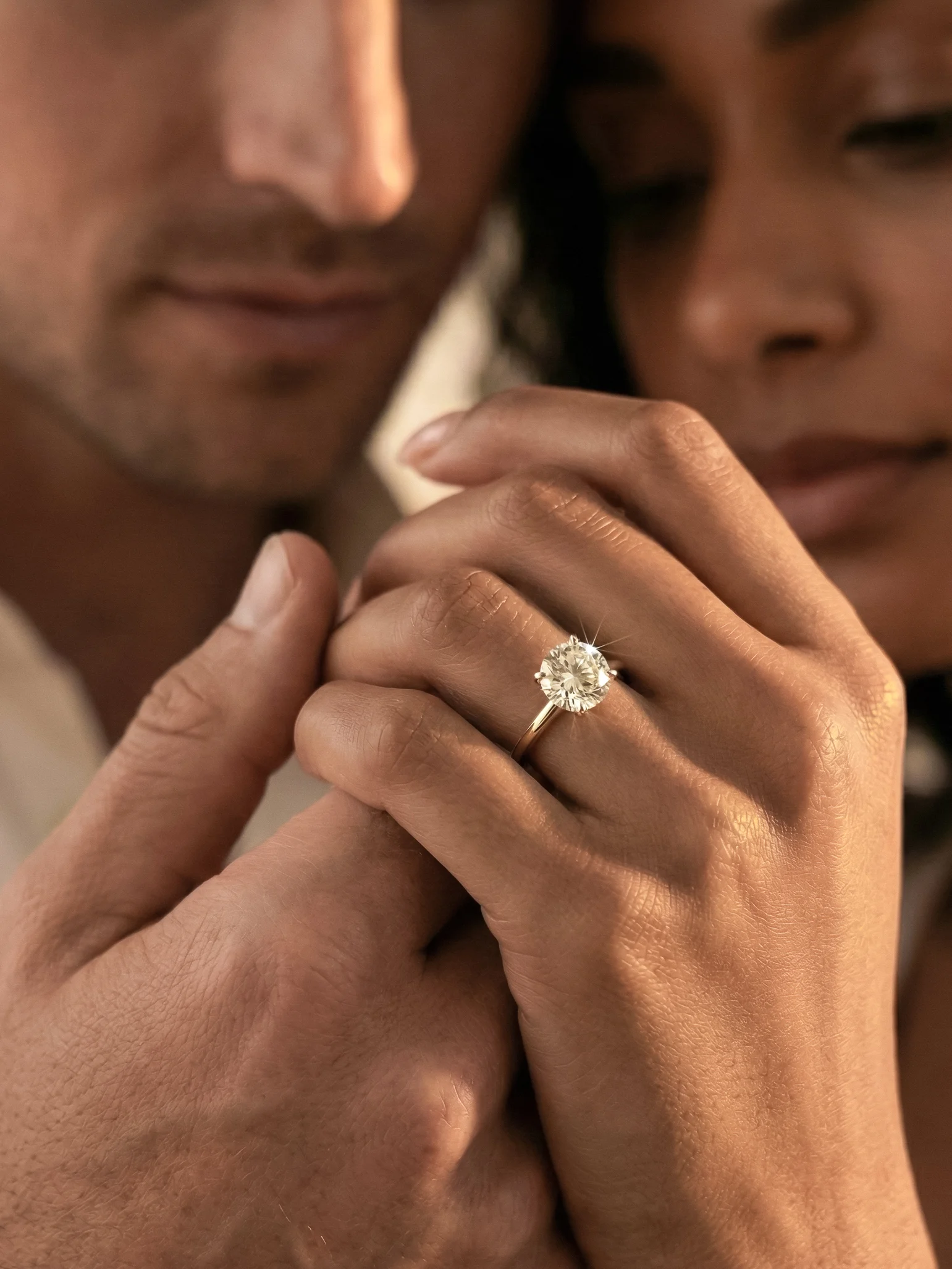 Man admiring a diamond engagement ring on a woman’s hand